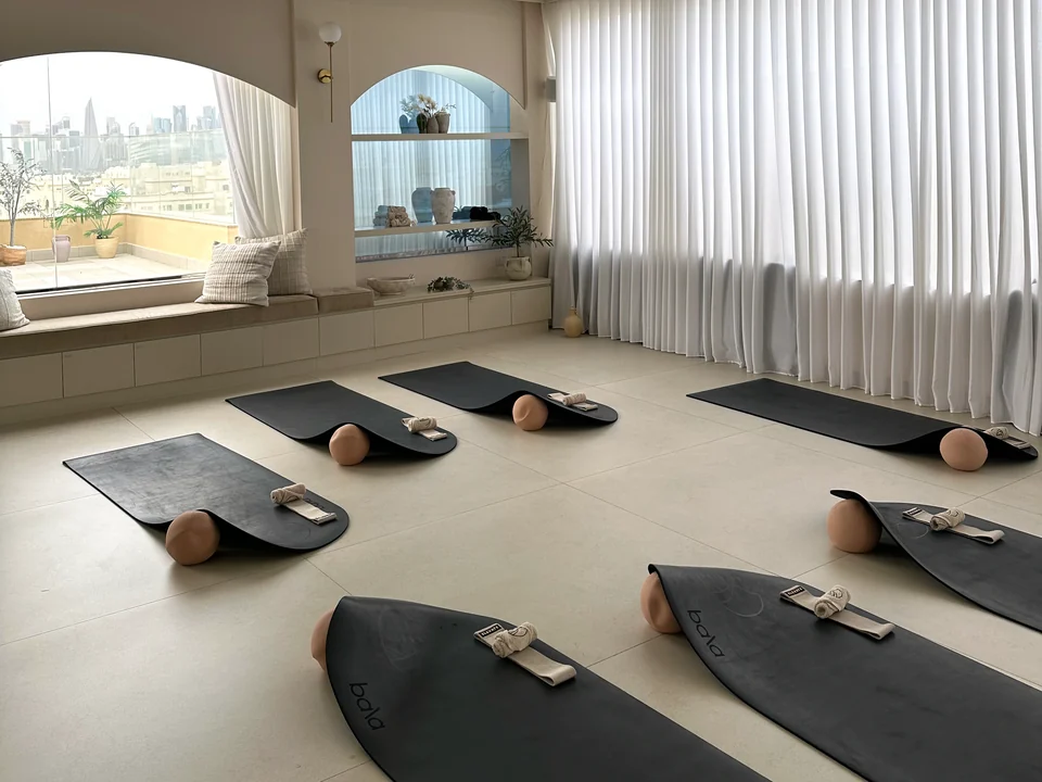 Mats and exercise props laid out beside sheer curtains and an arched window at Elevate.